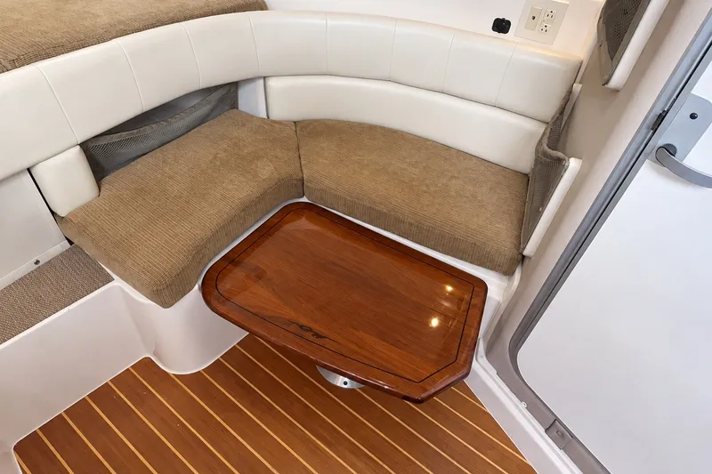 Slide: The Image of Interior of 2008 Grady-White Express 330 with cushioned seating and wooden table. - 39
