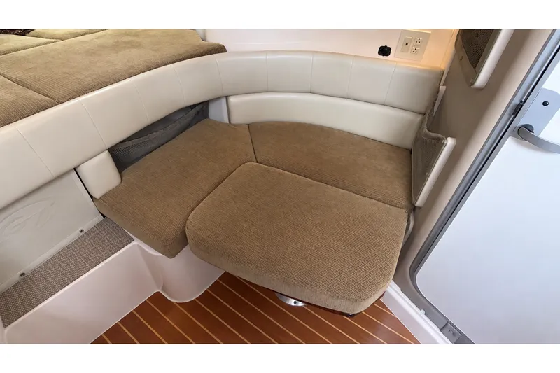 Slide: The Image of 2008 Grady-White Express 330 cabin seating with beige upholstery and wood flooring. - 40