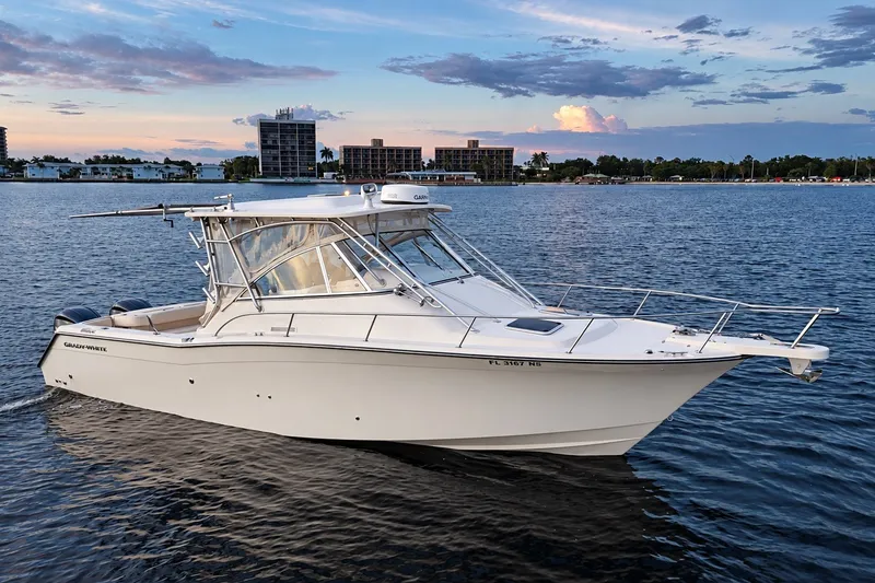 Slide: The Image of 2008 Grady-White Express 330 boat on calm water at sunset, cityscape in background. - 4