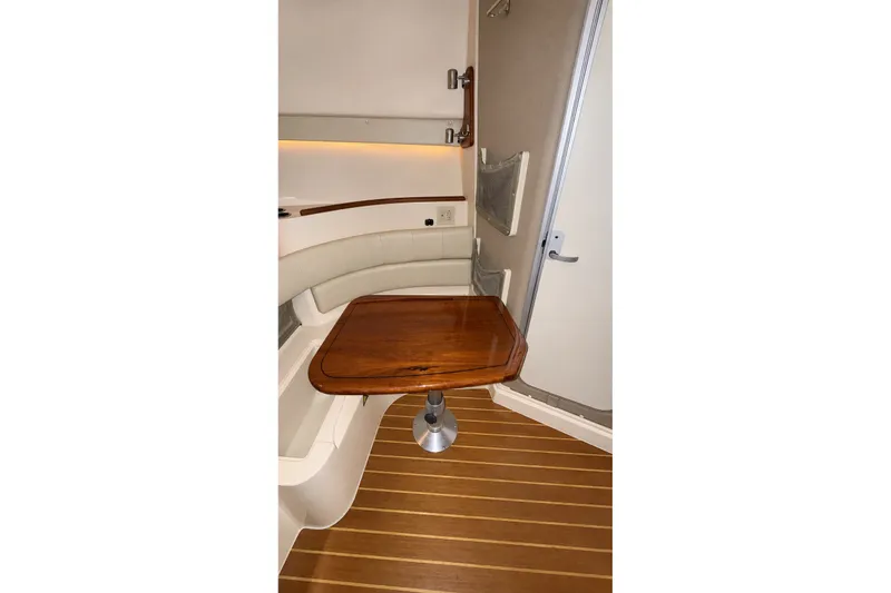 Slide: The Image of 2008 Grady-White Express 330 cabin interior with wooden table and seating area. - 27