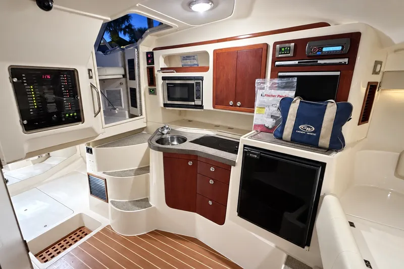 Slide: The Image of 2008 Grady-White Express 330 cabin interior with kitchenette, microwave, and compact fridge. - 30