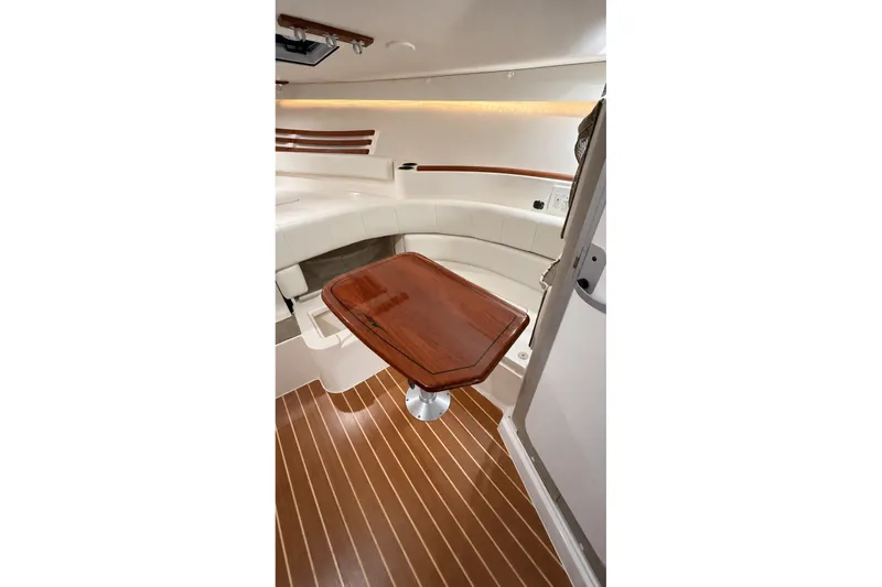 Slide: The Image of 2008 Grady-White Express 330 cabin interior with wooden table and seating. - 28