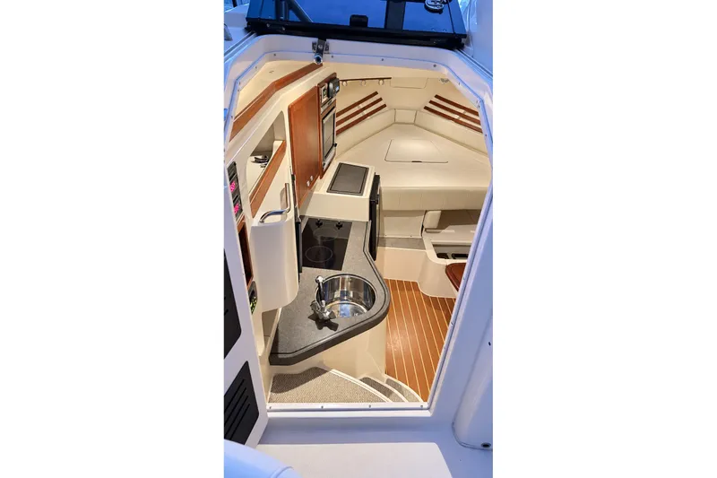 Slide: The Image of Interior of 2008 Grady-White Express 330 boat, featuring compact kitchen and seating area. - 24