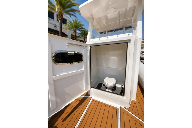 Slide: The Image of 2027 Tide Craft 26 Capri boat interior with modern marine toilet and wooden flooring. - 15