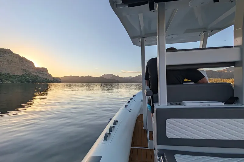 Slide: The Image of 2027 Tide Craft 26 Capri boat cruising on a serene lake at sunset. - 5