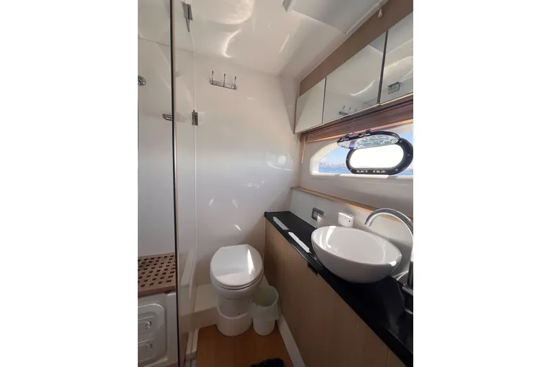 Slide: The Image of Luxurious bathroom in 2018 Aquila 44 Yacht with modern fixtures and porthole window. - 49