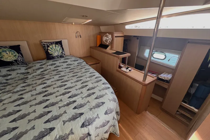 Slide: The Image of Luxurious 2018 Aquila 44 Yacht cabin with fish-patterned bedding and modern wood interior. - 48