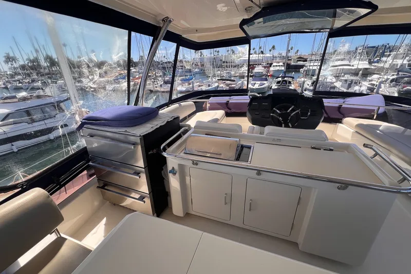 Slide: The Image of Interior view of 2018 Aquila 44 Yacht, featuring helm and seating area in marina setting. - 17