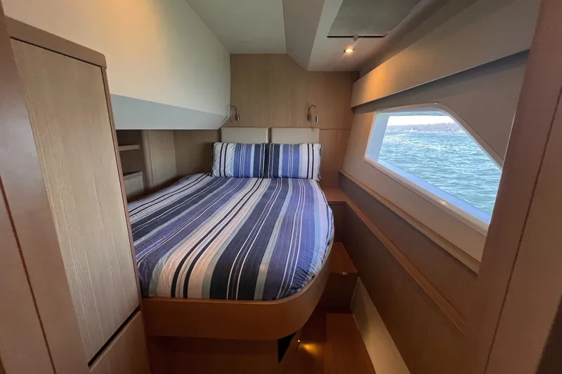 Slide: The Image of Interior cabin of 2018 Aquila 44 Yacht with striped bedding and ocean view. - 38