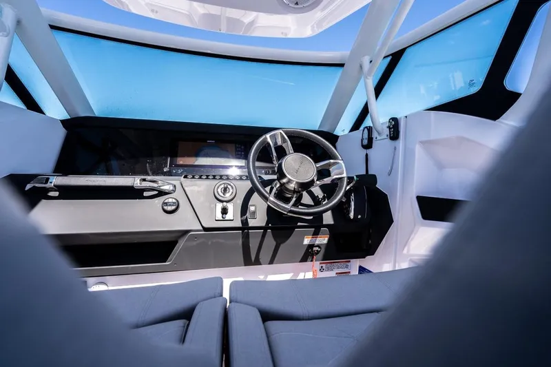 Slide: The Image of Interior view of 2027 Axopar 29 Sun-Top boat cockpit with steering wheel and dashboard. - 11