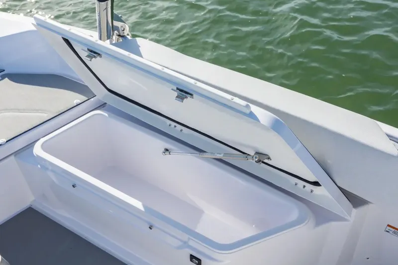 Slide: The Image of Open storage compartment on 2027 Axopar 29 Sun-Top boat, near water. - 13