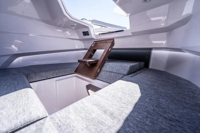 Slide: The Image of Interior cabin of 2027 Axopar 29 Sun-Top boat with gray cushions and wooden ladder. - 16