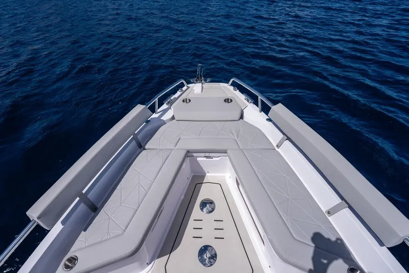Slide: The Image of 2027 Axopar 29 Sun-Top boat deck with cushioned seating on open water. - 6
