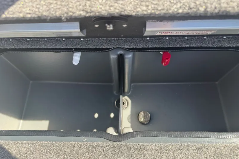 Slide: The Image of 2027 Ranger RT198P boat storage compartment with carpeted edges and drainage features. - 22