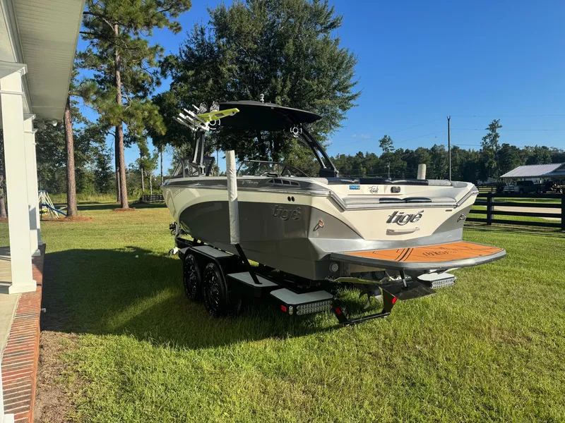 Slide: The Image of 2018 Tigé R23 on a trailer outdoors, surrounded by trees and grass. - 4
