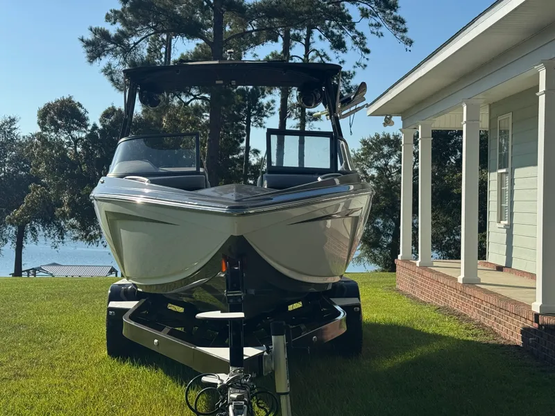 The Image of A white 2018 Tigé R23 boat on a trailer beside a house overlooking a lake. - 0