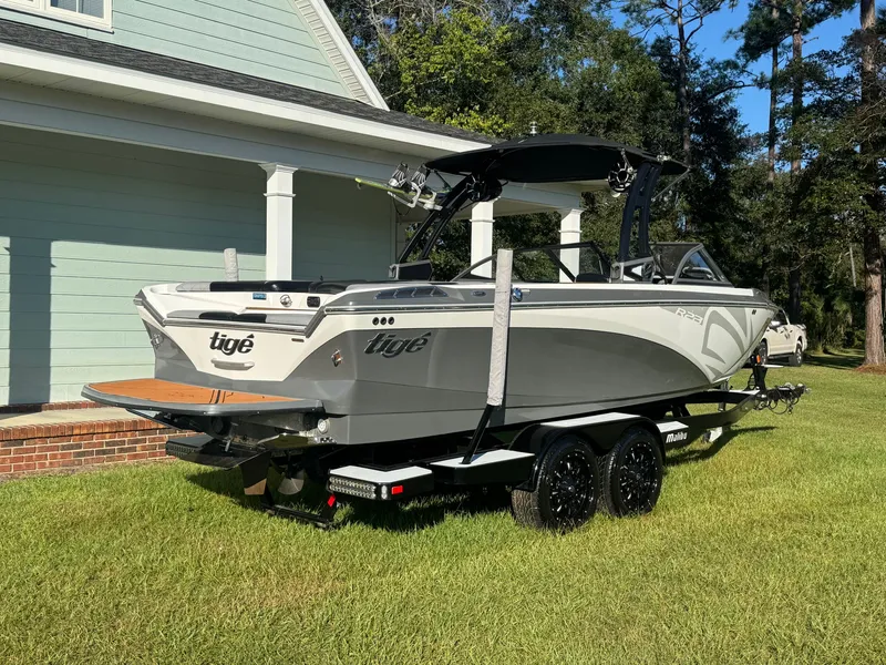 Slide: The Image of A gray 2018 Tigé R23 boat on a trailer beside a house. - 3