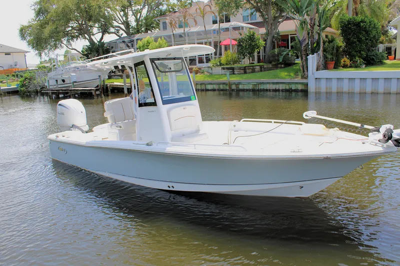 Slide: The Image of 2022 Sea Hunt BX25FS boat on calm water near residential area. - 3