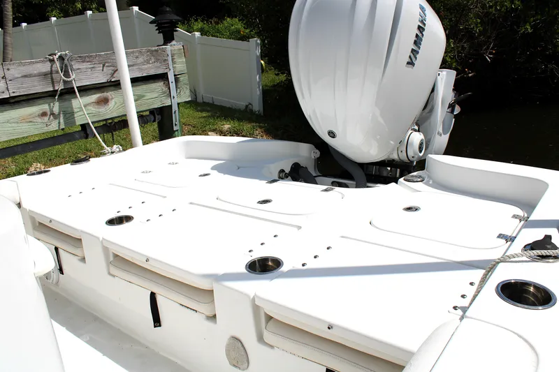 Slide: The Image of 2022 Sea Hunt BX25FS boat with Yamaha outboard motor, docked near wooden fence. - 9