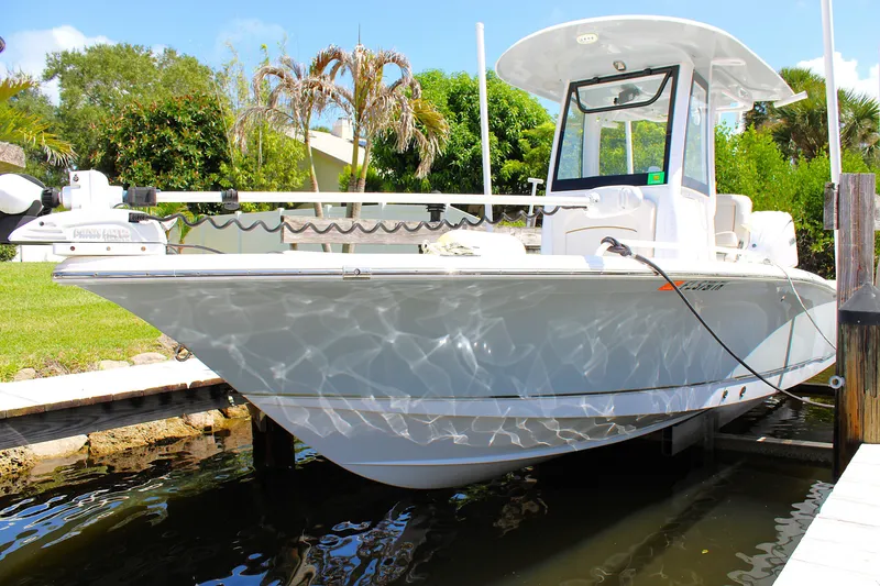 Slide: The Image of 2022 Sea Hunt BX25FS boat docked in a sunny, tropical setting. - 4