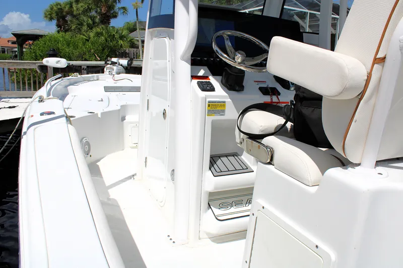 Slide: The Image of 2022 Sea Hunt BX25FS boat interior with steering wheel and seating. - 19