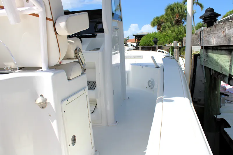 Slide: The Image of 2022 Sea Hunt BX25FS boat docked, showcasing sleek white interior and seating. - 20