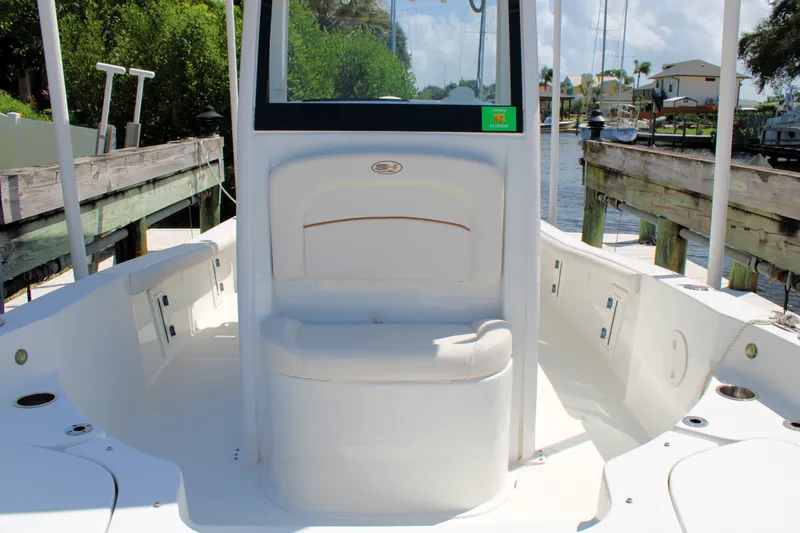 Slide: The Image of 2022 Sea Hunt BX25FS boat interior with seating, docked by a wooden pier. - 32