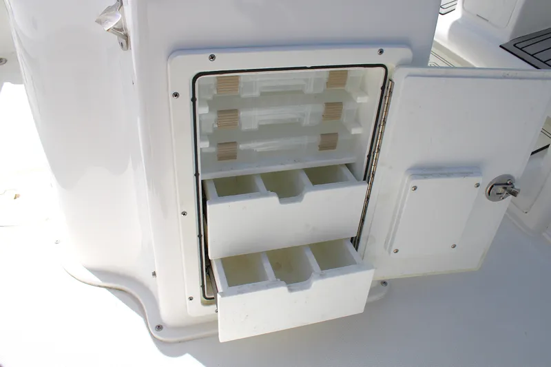 Slide: The Image of 2022 Sea Hunt BX25FS boat storage compartment with open drawers and shelves. - 15