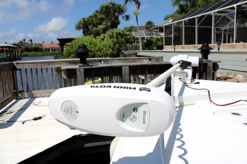 Slide: The Image of 2022 Sea Hunt BX25FS boat with Minn Kota Riptide trolling motor docked by a scenic waterfront. - 39
