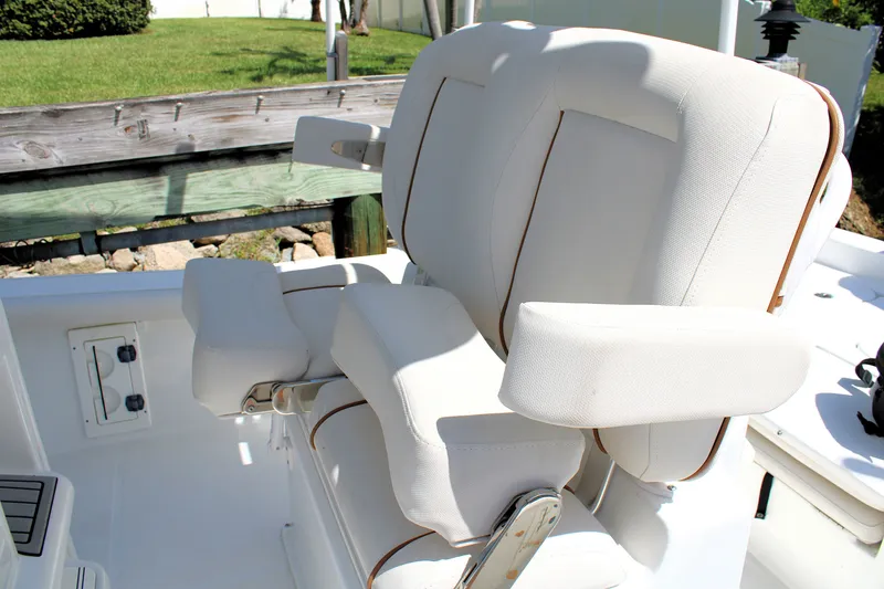 Slide: The Image of 2022 Sea Hunt BX25FS boat with white cushioned seating and armrests. - 30