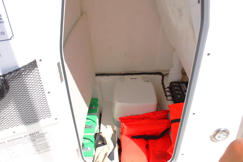 Slide: The Image of 2022 Sea Hunt BX25FS boat storage area with life jackets and supplies. - 13