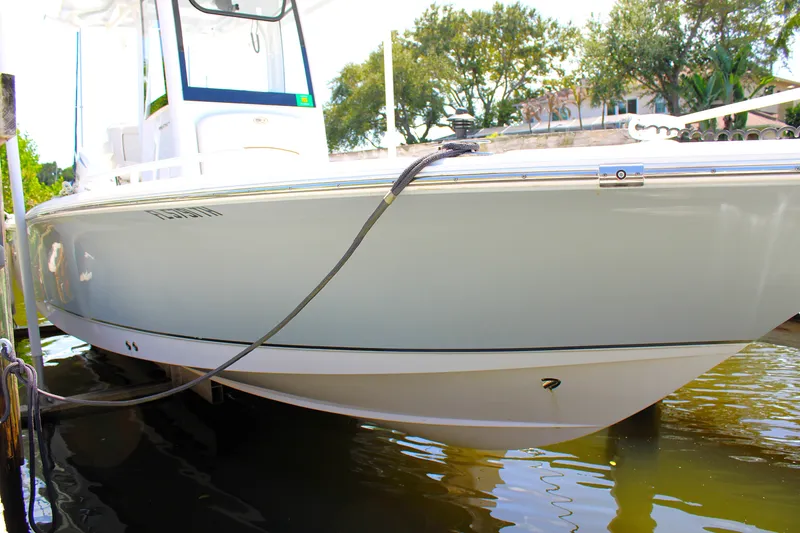Slide: The Image of 2022 Sea Hunt BX25FS boat docked in calm water, side view. - 5