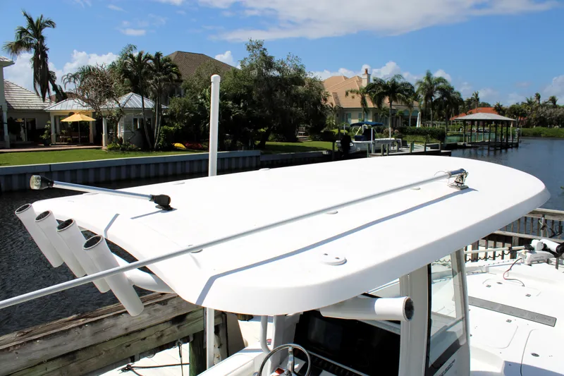 Slide: The Image of 2022 Sea Hunt BX25FS boat docked by waterfront homes under a clear blue sky. - 23