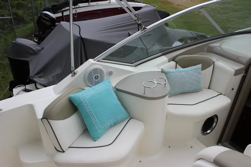 Slide: The Image of 2007 Sea Ray 240 Sundancer boat interior with cushioned seating and teal pillows. - 26