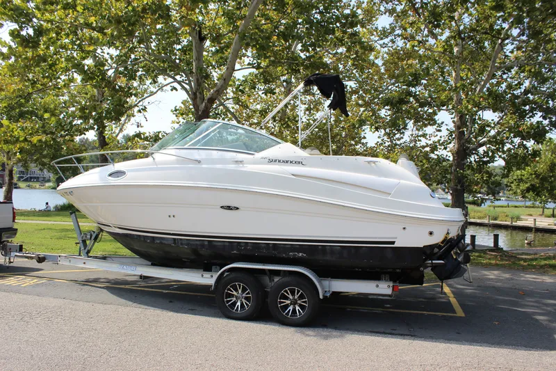 Slide: The Image of 2007 Sea Ray 240 Sundancer boat on trailer, parked near a scenic lake. - 40