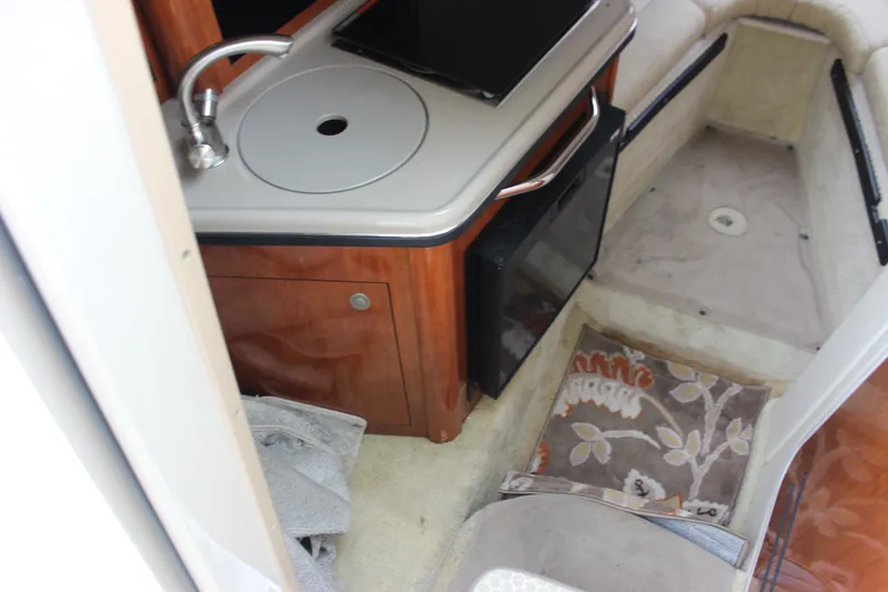Slide: The Image of 2007 Sea Ray 240 Sundancer cabin interior with sink, countertop, and seating area. - 21