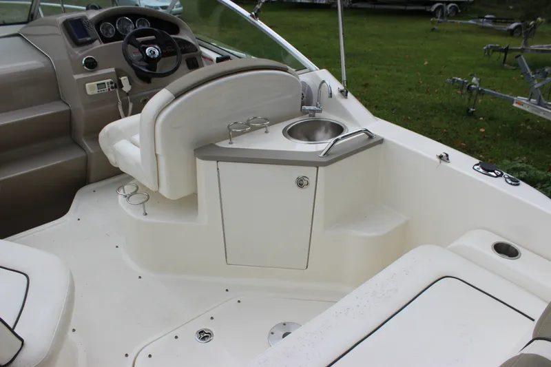Slide: The Image of 2007 Sea Ray 240 Sundancer cockpit with helm, sink, and seating area. - 14