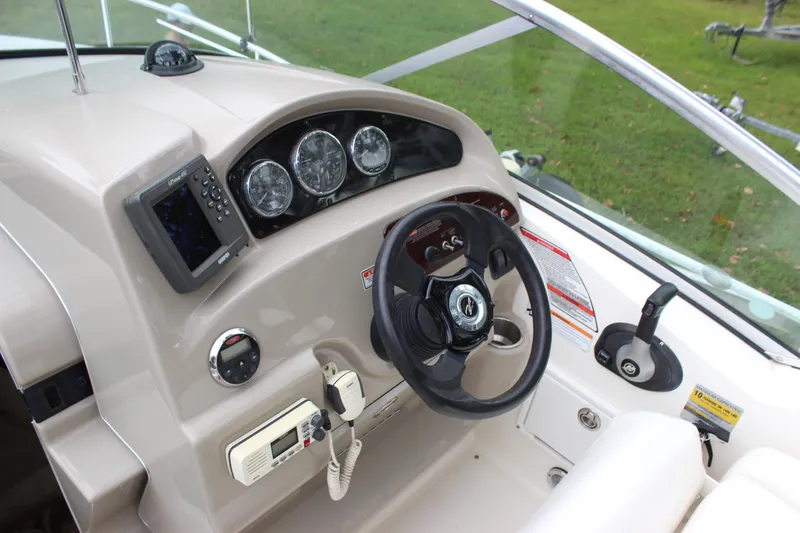 Slide: The Image of 2007 Sea Ray 240 Sundancer helm with steering wheel and navigation instruments. - 23