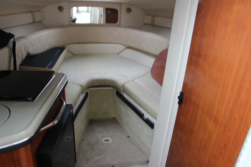 Slide: The Image of Interior cabin of 2007 Sea Ray 240 Sundancer with beige seating and wooden accents. - 22