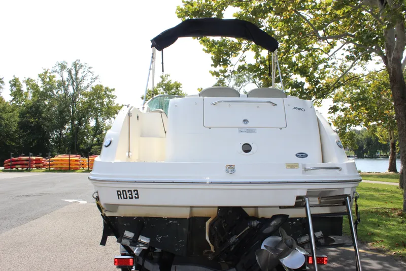 Slide: The Image of 2007 Sea Ray 240 Sundancer boat, rear view, parked near a lake with trees. - 37