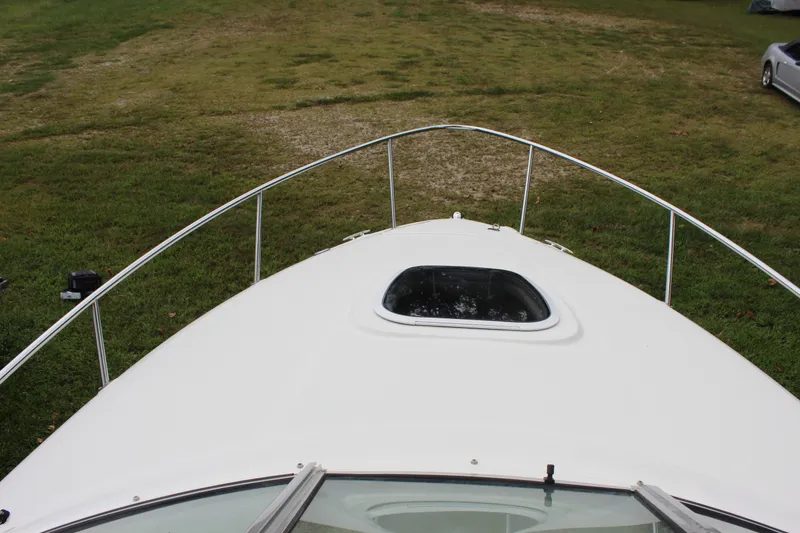 Slide: The Image of 2007 Sea Ray 240 Sundancer boat bow view with hatch, parked on grass. - 34