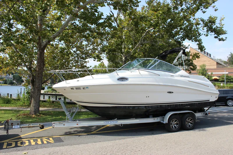 Slide: The Image of 2007 Sea Ray 240 Sundancer boat on trailer, parked near a lake with trees. - 38