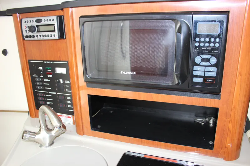 Slide: The Image of 2007 Sea Ray 240 Sundancer galley with microwave, control panel, and faucet. - 28