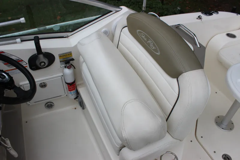 Slide: The Image of 2007 Sea Ray 240 Sundancer cockpit with steering wheel and white seating. - 35