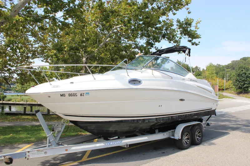 Slide: The Image of 2007 Sea Ray 240 Sundancer boat on trailer, parked near trees and road. - 39