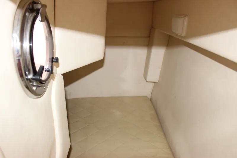 Slide: The Image of Interior cabin of 2007 Sea Ray 240 Sundancer with porthole window and beige upholstery. - 18