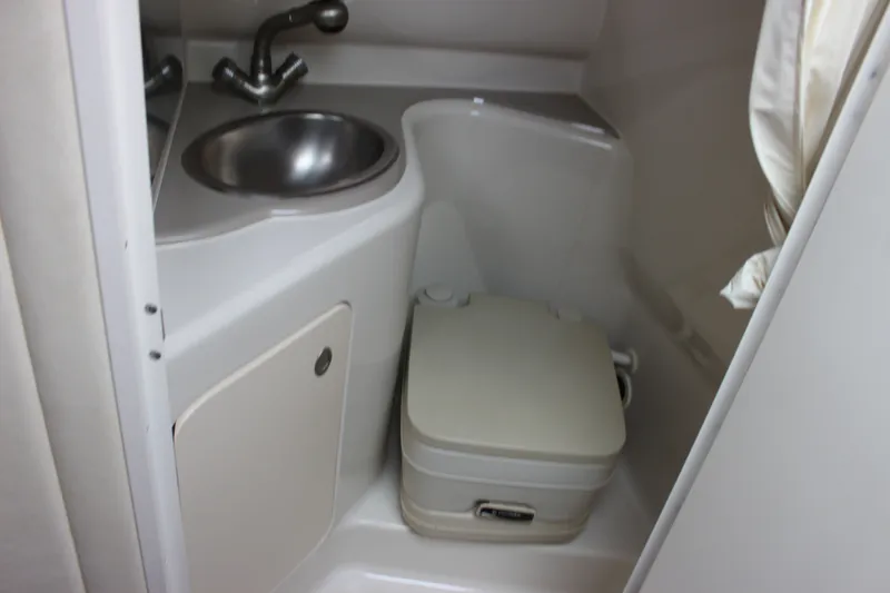 Slide: The Image of Compact bathroom in 2007 Sea Ray 240 Sundancer with sink and portable toilet. - 31