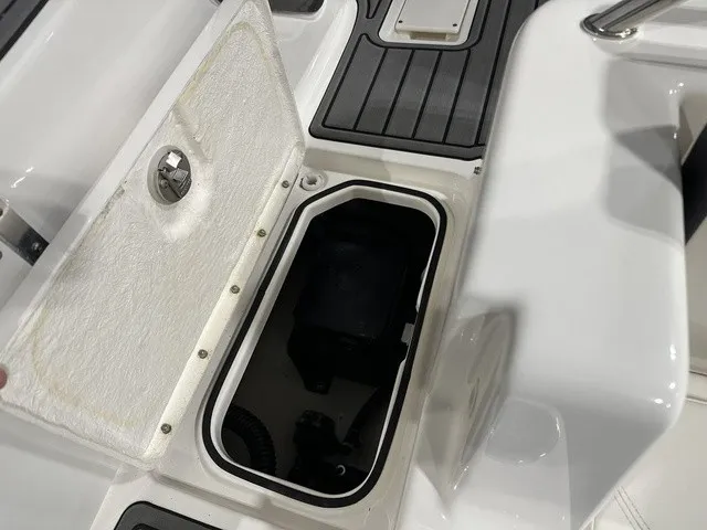 Slide: The Image of An open storage compartment on a boat with gray flooring and white interior. - 12