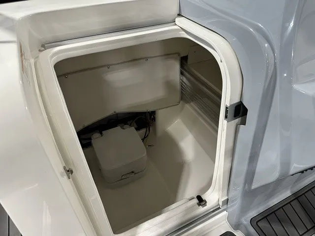 Slide: The Image of An open storage compartment on a boat with a white interior. - 25