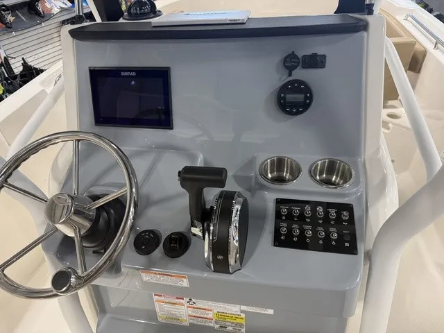 Slide: The Image of The image shows the helm of a 2025 Trophy T24CC boat with a steering wheel and instruments. - 18